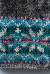 close up of a knitted snowflake pattern in blue and white